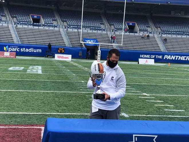 Calvary Day head coach Chad Griffin holds the trophy after the GHSA Class 1A-5A state championship game, which the Cavaliers won 6-0 over Portal on Dec. 28, 2020 at Center Parc Stadium in Atlanta.