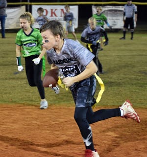 Raider quarterback Baker Giles looks to make a handoff while surrounded by Seahawks. The Raiders went on to win the youth flag football game 44-30.