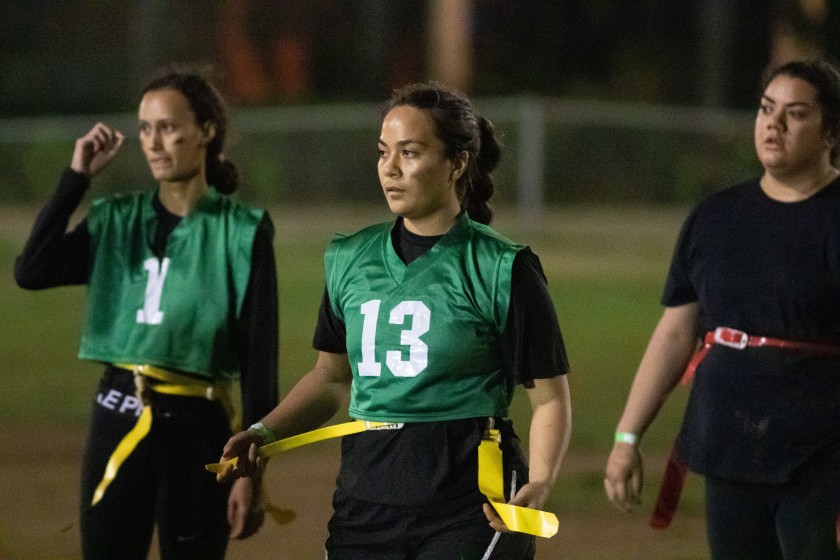 Female players hold their yellow flags on the Rugby Field at BYUH. 
