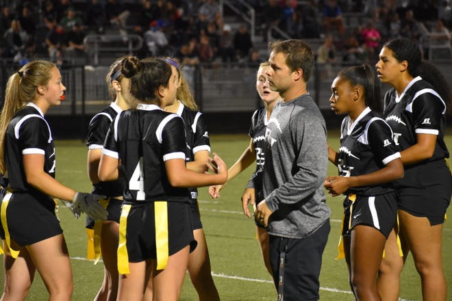 Richmond Hill flag football coach Tony Dragon talks with his squad during a game this year.