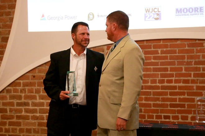 Calvary Day School athletics director Chad Griffin, left, who also coaches the boys and girls soccer teams and the girls flag football team, receives the Savannah Sports Council Award of Excellence from director Rob Wells on Tuesday during the annual Georgia Power Sports Awards Luncheon.