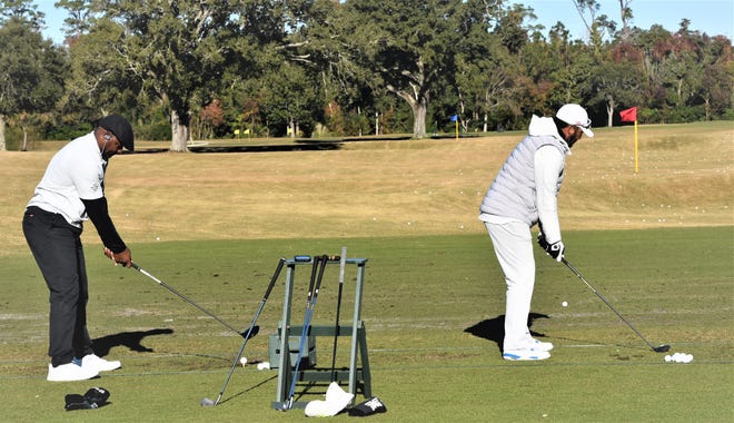 Derrick Brooks and former MLB baseball star Gary Sheffield warm up on the practice range prior to the Derrick Brooks Charity Golf Tournament at Pensacola Country Club.