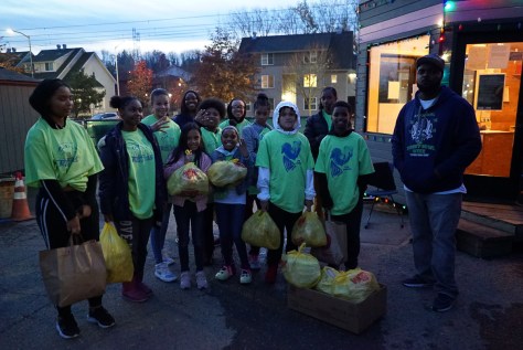 Photo depicting a group of youth volunteers gathered together with kits to deliver.