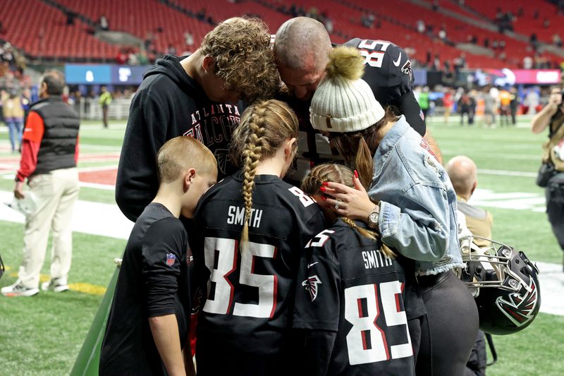 Falcons tight end Lee Smith, top right, shares a moment with his family after their loss against the New Orleans Saints 30-20 at Mercedes-Benz Stadium, Sunday, January 9, 2022, in Atlanta. JASON GETZ FOR THE ATLANTA JOURNAL-CONSTITUTION



