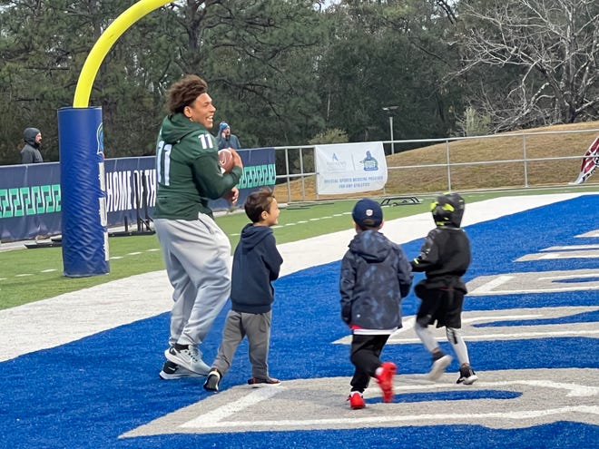 Michigan State running back Connor Heyward shares laughter with young participants in the Reese's Senior Bowl clinic Thursday at UWF Pen-Air Field.