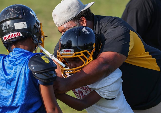 Coach Donnell Hamilton works with an Indy Steelers youth football player Tuesday, July 23, 2019, during practice at Tarkington Park.