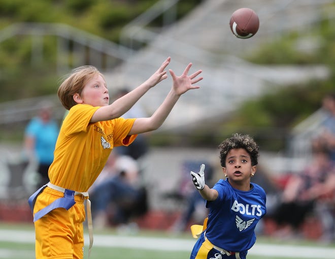 A Commanders player makes a catch against the Bolts as flag football teams compete at Central Kitsap's Cougar Field on Thursday, June 23, 2022. The Peninsula Flag League fields teams of players from kindergarten through eighth grade.