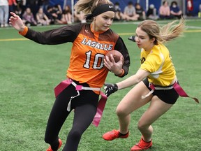 Jasmine Savignac, left, of the Lasalle Lancers, attempts to evade Naomi Schmidt, of Bishop Alexander Carter, during flag football action at the Lancer Flag Football Senior Tournament at the Lancer Dome in Sudbury, Ont. on Thursday April 28, 2022. John Lappa/Sudbury Star/Postmedia Network
