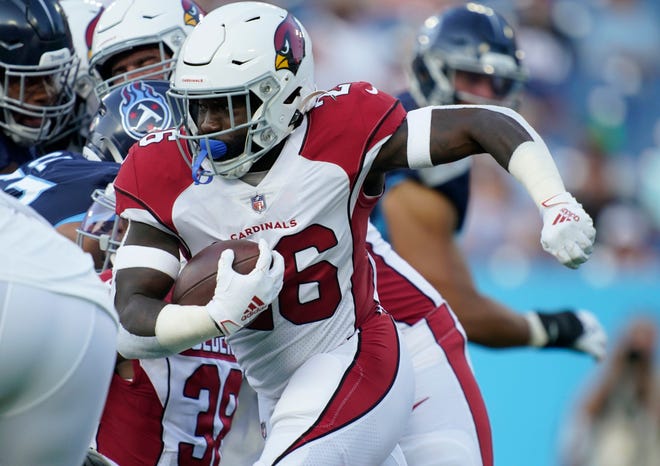 Arizona Cardinals running back Eno Benjamin (26) runs through the Tennessee Titans defense during the first quarter of an NFL preseason game against the Tennessee Titans at Nissan Stadium Saturday, Aug. 27, 2022, in Nashville, Tenn.