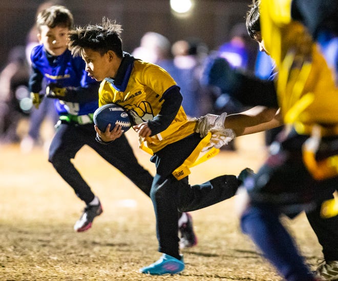 Roosevelt Elementary's Arian 'Mowgli' Garcia, 9, makes a carry during the DSUSD Elementary Flag Football League Championships at Colonel Mitchell Paige Middle School in La Quinta, Calif., Friday, Dec. 9, 2022. 