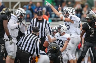 The officials look at one another while determining which team recovered a fumble during a PIAA semifinal game between Neumann Goretti and Wyomissing at the Germantown Supersite in Philadelphia on Saturday, Dec. 3, 2022. There is a shortage of referees for high school football.