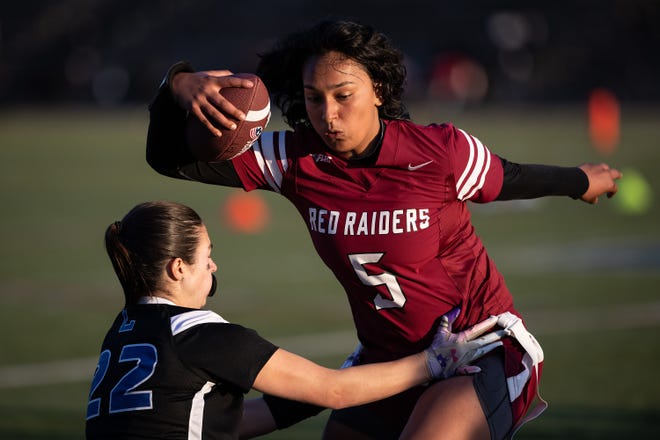 Fitchburg's Gia Santiago is tagged by Leominster's Madison Paine in the inaugural flag football game Thursday sponsored by the New England Patriots at Doyle Field in Leominster.