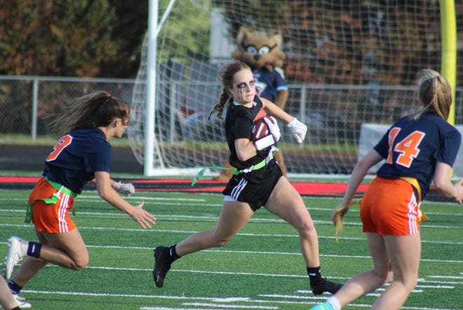 Ravenwood running back Laurie Crawford runs the ball as she tries to avoid two Summit defenders during the Lady Raptors' 20-6 win over Summit.