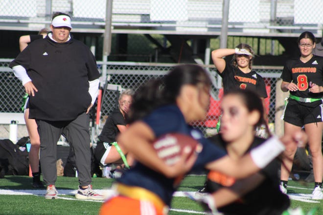 Ravenwood coach Will Hester looks on as Summit quarterback Nicole Rizane runs the fooball.