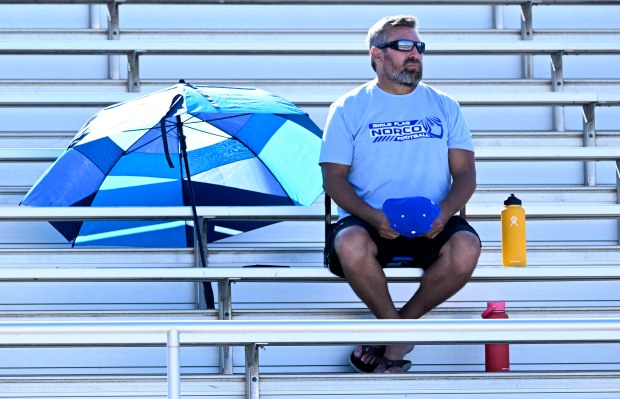 A Norco Girls flag football fan watches warmups before the...