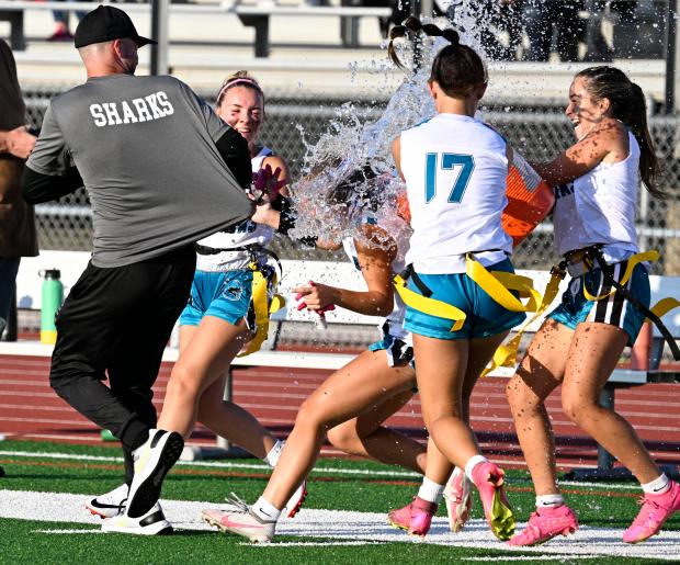 Santiago players try to douse a coach with water after...