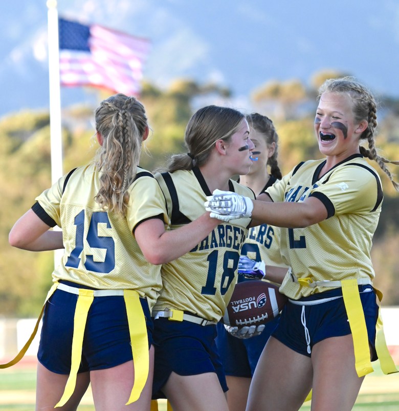 Freshman Brooklyn Hedricks (18) celebrates her touchdown catch with Dos Pueblos High School seniors Katie Peterson (15) and Maddy Jones (2) during the Chargers’ first flag football game.  The Chargers are currently 2-0 on the season after Thursday’s 25-6 win over Buena. (Lily Chubb / Noozhawk photo)