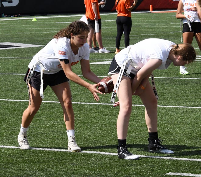 These girls make a clean pass from center at the girls flag football kickoff jamboree sponsored by USA Flag Football and the Cincinnati Bengals at Paycor Stadium, Sept. 30, 2023.