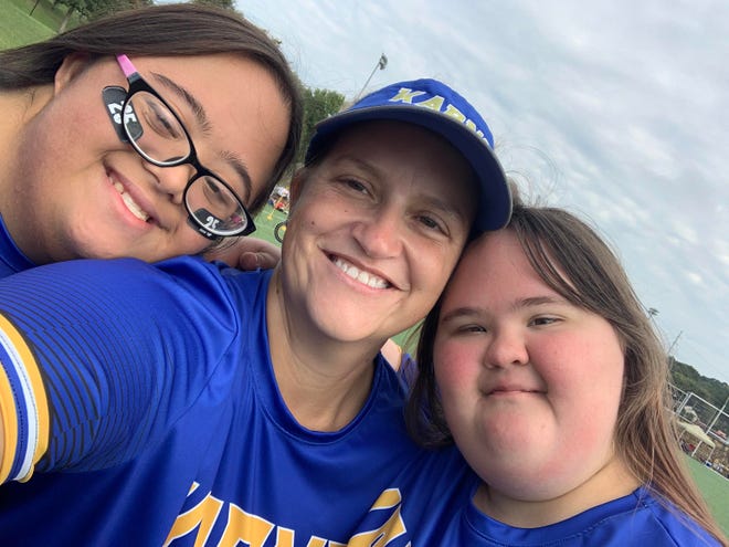 Karns High School Special Olympians Bianca Dalit and Rebekah Cobble, with Karns High School Special Olympics coach Kiley Heyward (center), participate Sept. 9, 2023, at the regional flag football invitational at the UT RecSports Field on Sutherland Avenue in Knoxville, Tennessee.