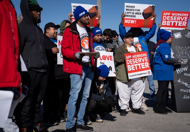 Drivers from the Justice for App Workers Coalition rally during their one-day strike at O'Hare International Airport ride-share staging lot on Wednesday, Feb. 14, 2024. The drivers are striking to draw attention to violence against ride-share workers, lack of job protections against app deactivations, and lagging wages. (E. Jason Wambsgans/Chicago Tribune)