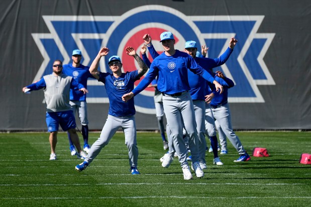 Chicago Cubs players run during a MLB baseball spring training workout, Wednesday, Feb. 14, 2024, in Mesa, Ariz. (AP Photo/Matt York)