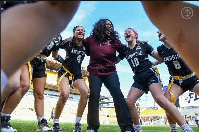 Ambridge girls flag football coach Felicia Mycyk gets fired up with her team on the field at Acrisure Stadium for the girls flag football league kickoff in April.